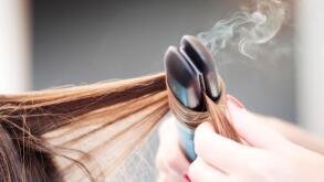 Hairdresser Applying a Straight Iron on a Woman Hairdo
