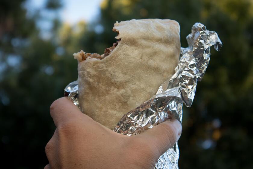 Holding Carne Asada Burrito Wrapped in Foil