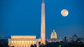 Supermoon above three iconic monuments: Lincoln Memorial, Washington Monument and Capitol Building in Washington DC as viewed from Arlington, Virginia