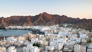 Dusk view of the district of Mutrah and surrounding mountains in Muscat, the capital of the Sultanate of Oman.
