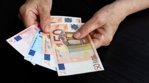 Elderly woman with euro notes in wrinkled hands. Concept of pension payments, savings at retirement, pensioner with money