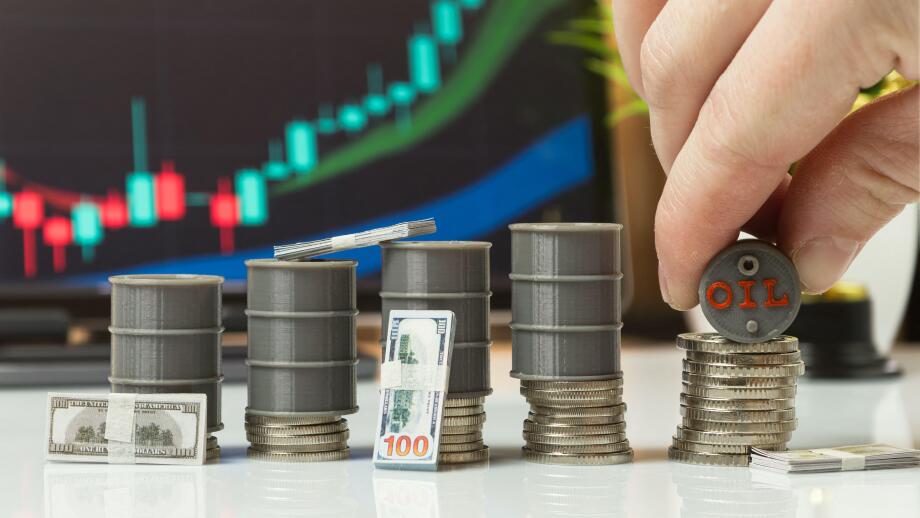 Hand Stacking Oil Barrel on Coins with Cash and Trading Chart