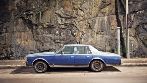 A blue car against a stone wall, Sweden.