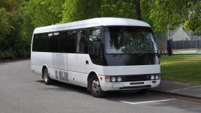 A small white tour coach, bus or mini-van used to transport passengers and tourists. Typically used for small group tours of around 21 passengers.