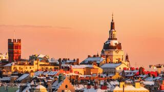 Katarina Church and the roof tops of the district of Sodermalm, Stockholm, at sunset, clear sky, winter, snow. Pink orange colors.