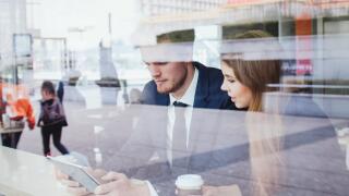 business people in cafe looking at the screen of tablet