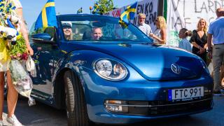 Ronneby, Sweden - June 15, 2018: Upper secondary school graduation day. Happy female student riding away in a blue 2015 Volkswagen Beetle from school