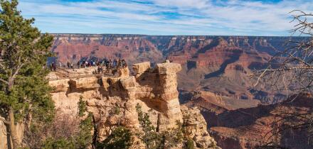 Grand Canyon national park, Arizona. Tourists admiring the panoramic view from one of the view points on the south rim, in November, bright light