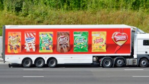 Nestle hgv supply chain delivery lorry truck & articulated trailer colourful advertising display of its  products driving along M25 Motorway Essex UK