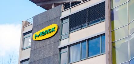 Yellow green Merck logo at the wall of a Merck office building. Merck is one of the largest pharmaceutical companies in the world. Darmstadt, Germany.
