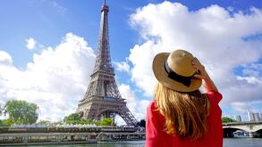 Holidays in Paris. Back view of beautiful fashion girl enjoying view of Eiffel Tower in Paris, France. Summer vacation in Europe.