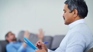 Talking is the best therapy. Shot of a therapist taking notes while listening to a patient during a counseling session.
