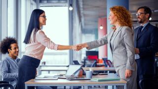 Two businesswomen shaking hands.