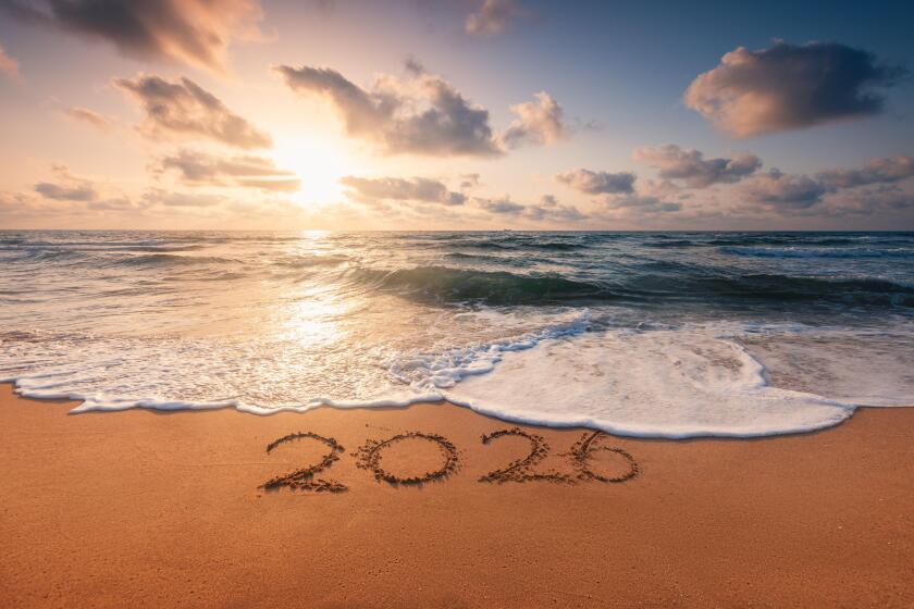 Happy New Year 2026 concept, lettering on the beach. Written text on the sea beach at sunrise.