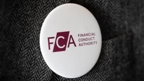 A button badge bearing the logo of FCA Financial Conduct Authority fastened to a suit jacket.