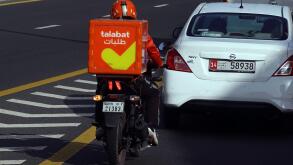 22.03.2022, Dubai, , United Arab Emirates - Employee of food delivery service talabat riding a motorcycle in the city. 00S220322D902CAROEX.JPG [MODEL