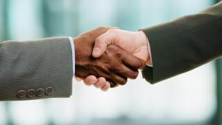 Interracial handshake on business background