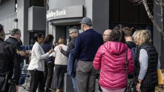 Santa Clara, United States. 13th Mar, 2023. An employee hands out papers to customers queued up for admittance at the collapsed Silicon Valley Bank in Santa Clara, California on Monday, March 13, 2023. President Biden spoke assuring Americans that the U.S