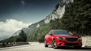 Red car standing on the road near mountains at daytime
