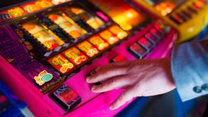 a man's hand on a fruit machine gambling