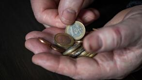 Old male hand holding euro coins, close up. Hands hold euro coins of different denominations. Inflation, purchasing power and social crisis