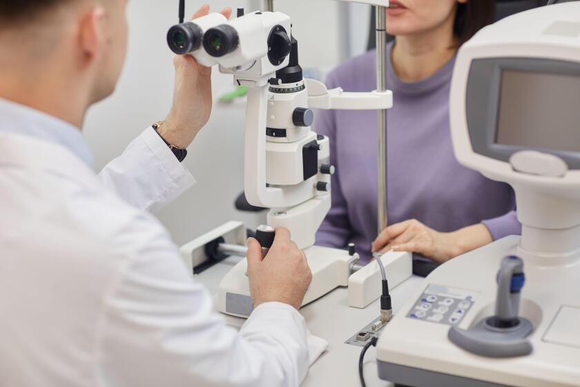 Cropped portrait of young woman using machines during vision test in modern opthalmology clinic, copy space