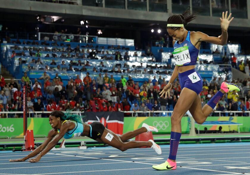 FILE - In this Aug. 15, 2016, file photo, Bahamas' Shaunae Miller-Uibo falls over the finish line to win gold ahead of United States' Allyson Felix, right, in the women's 400-meter final during the athletics competitions of the 2016 Summer Olympics at the