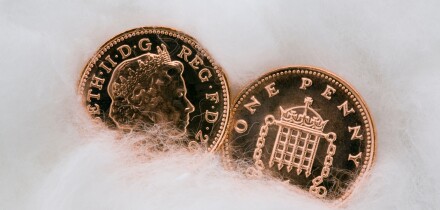 Two copper penny coins in close up wrapped in cotton wool for protection. Protecting money and austerity concept. UK