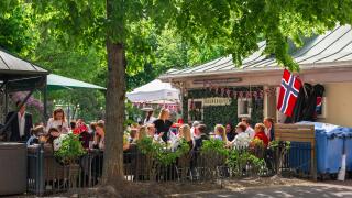 Oslo, view in late spring of Norwegian people relaxing at tables at a restaurant in Olaf Ryes Plass park in the Grunerlokka area of Oslo, Norway.
