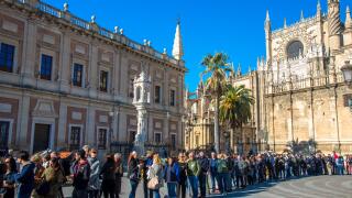 tourists waiting in line for entrance of Real Alcazar, palace in Sevilla, Spain