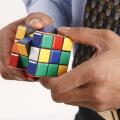 Businessman hand holding Rubik cube in both hands and trying to solve puzzle Model Release # 703T