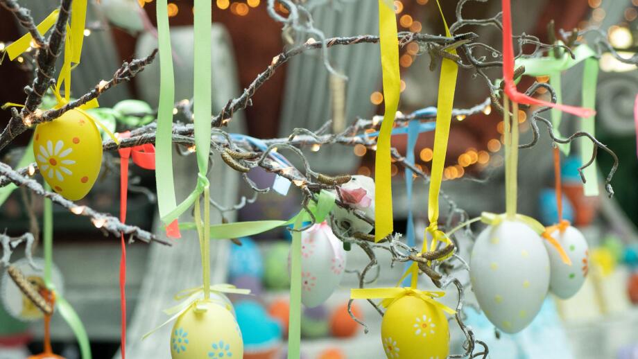 Decoration for Easter holiday celebration, selective focus. Eggs with ornament suspended in ribbons