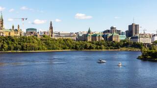 Ottawa, Canada - August 2, 2021: Parliament of Canada under renovation, cityscape and Ottawa river with boats in summer. Panoramic view from Alexandra