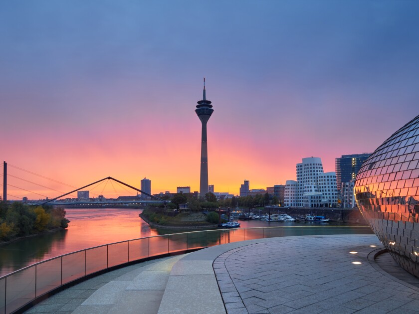 Rainy sunrise in the city of Dusseldorf in Germany. The urban landscape of the city of Düsseldorf. View of the Rheinkniebrücke bridge and the Media Harbor during the golden hour