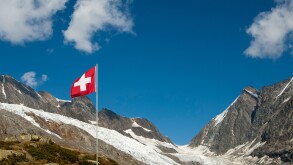 The Swiss flag near the mountain pass Loetschenluecke and the glacier Langgletscher, Loetschental, Valais, Switzerland