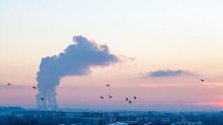 Climate change. Birds flying over Nottingham against an evening sky with greenhouse gas emissions from a power station, Nottinghamshire, England, UK