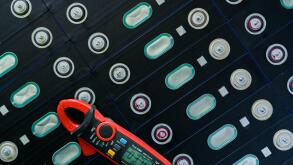 Electric vehicle lithium NMC battery with multimeter. Electric car battery manufacturing factory. Lithium-ion cell. Lithium NMC rechargeable battery.