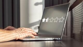 Man using laptop for negative online review. Giving bad feedback in satisfaction survey concept. Sad customer experience. High quality photo