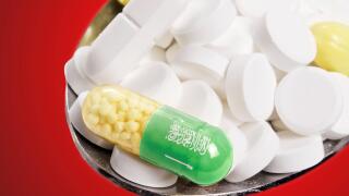 The national flag of Saudi Arabia on a capsule and pills on a spoon.(series)