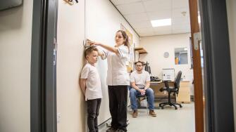 Medical professional measuring a child's height