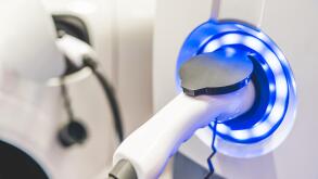 Electric Vehicle charging station system storing power on white modern car. EV fuel advanced hybrid car. automobile industry new technology concept.