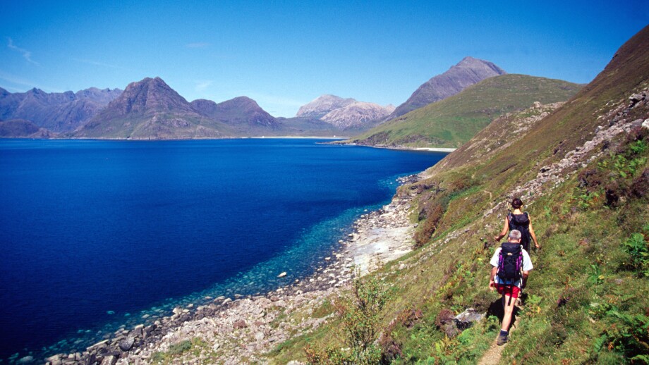 Walkers heading towards the Black Cuillin on the coastal path from Elgol, Isle of Skye, Scotland