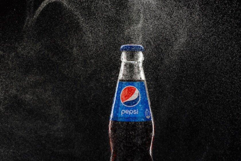 Misted Pepsi bottle on a black background among splashes of water close-up, LatAm, CBC, 575