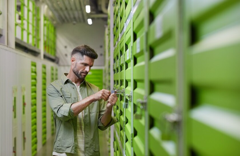 Man Opening Lock on Storage Unit