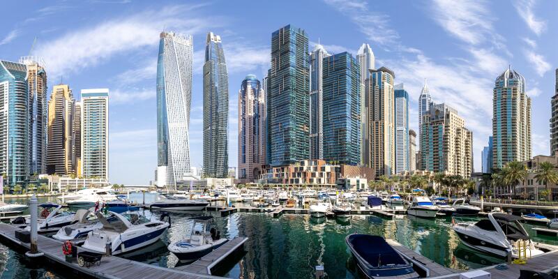 Dubai Marina skyline cityscape with yachts skyscraper real estate buildings living at water panorama boats