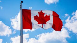 Canadian flag waving in the blue sky