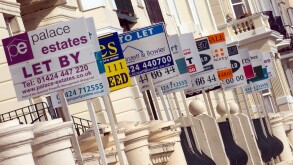 A row of Estate agents For Sale Sold Sale Agreed To Let and Let boards festoon a terrace of sea view houses on Hastings seafront