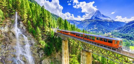 Zermatt, Switzerland. Gornergrat tourist train with waterfall, bridge and Matterhorn. Valais region.
