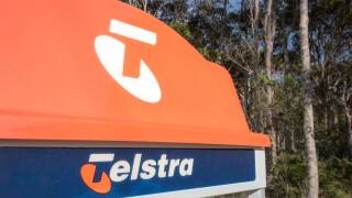 The distinctive orange top of a traditional Telstra public phone booth on a footpath in a rural village now almost redundant due to mobile phones