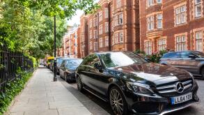 LONDON- JULY, 2020: Black Mercedes car  parked on beautiful street of Kensington townhouses